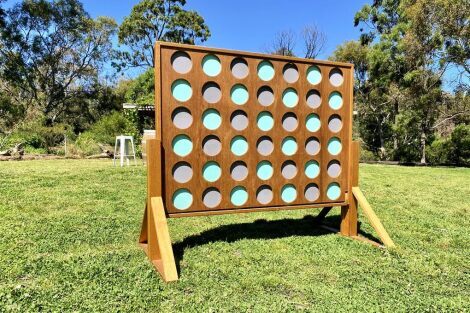 Image shows a Giant Connect 4 board, with colourful discs setup for a wedding